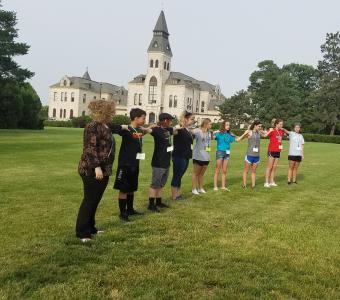 students standing arms to arms to measure wind turbine