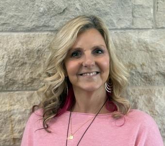 Stacy in front of limestone wall 2025