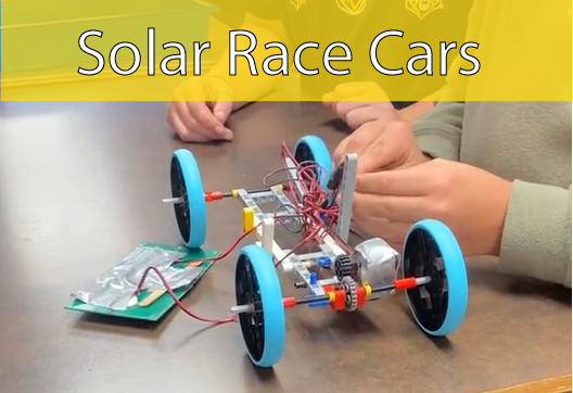 Small solar-powered race car with hands in background