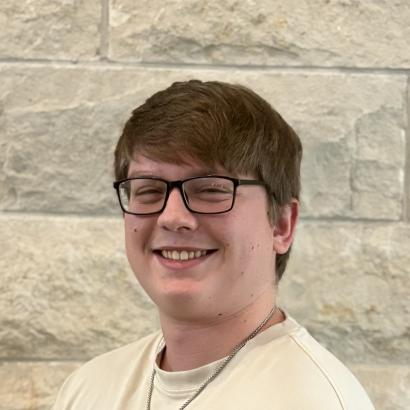 Brendan - headshot in front of limestone wall