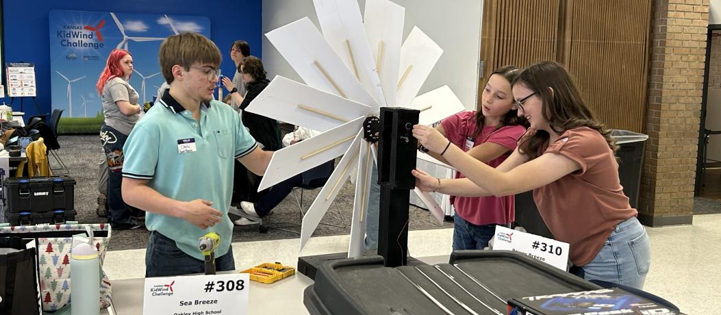 Students adjusting wind turbine on table