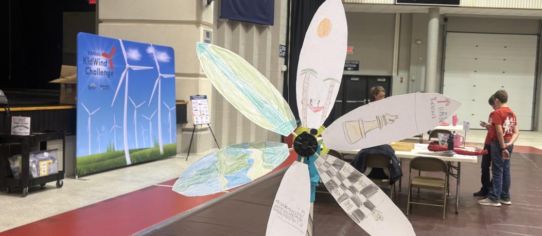 Wind turbine standing in front of KidWind sign